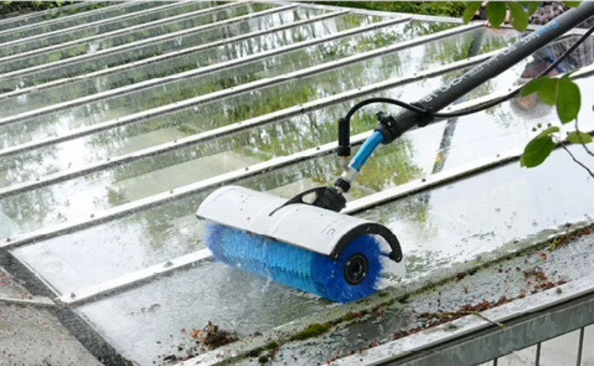 Heavily soiled glass surface is cleaned with a hand brush